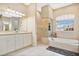 Bathroom boasts double vanity, a large soaking tub, a separate shower, and a window at 1556 Auburn Oaks Ct, Auburndale, FL 33823