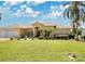 Single-story home with two-car garage, lush landscaping, and a large front yard at 1556 Auburn Oaks Ct, Auburndale, FL 33823