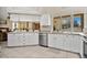 Well-equipped kitchen with white cabinets, island, stainless steel appliances, and view to living room at 1556 Auburn Oaks Ct, Auburndale, FL 33823