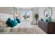 Main bedroom with a king-size bed, teal pillows, and a view to backyard at 4141 Giorgio Dr, Winter Haven, FL 33884