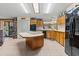This kitchen features wood cabinets, a large island, and a black refrigerator at 6399 Lolly Bay Ne Loop, Winter Haven, FL 33881