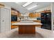 Kitchen with an island, wood cabinets, and black appliances at 6399 Lolly Bay Ne Loop, Winter Haven, FL 33881