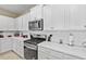 Clean kitchen with white cabinets, stainless steel appliances and quartz countertops at 7160 Oakmoss Loop Loop, Davenport, FL 33837