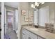 Bright bathroom with a granite countertop, white cabinets, and a large mirror at 3875 Grassland Loop, Lake Mary, FL 32746