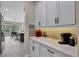 Kitchen features white cabinets, marble countertops, and coffee bar at 3875 Grassland Loop, Lake Mary, FL 32746