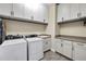 Laundry room with matching washer, dryer, and white cabinets at 3875 Grassland Loop, Lake Mary, FL 32746