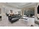 Open living room with sectional sofa and view of kitchen and pool at 3875 Grassland Loop, Lake Mary, FL 32746