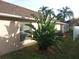 Landscaped backyard with tropical plants and a screened patio at 7947 Golden Pond Cir, Kissimmee, FL 34747