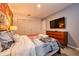Bedroom with city themed wall mural, large TV, and dresser at 8929 Amelia Downs Trl, Kissimmee, FL 34747