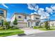 Two-story house with light-colored siding, a three-car garage, and landscaping at 8929 Amelia Downs Trl, Kissimmee, FL 34747