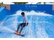 Person surfs on the FlowRider wave simulator at Solara Resort at 8929 Amelia Downs Trl, Kissimmee, FL 34747
