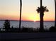 Stunning sunset over calm water, palm trees, and a quiet dock at 110 Cypress Woods Ct # 5C, Deltona, FL 32725