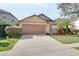 Single-story house with brown garage door and landscaped lawn at 12755 Oulton Cir, Orlando, FL 32832