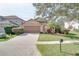 Tan one-story house with brown garage door, landscaping, and driveway at 12755 Oulton Cir, Orlando, FL 32832