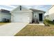 Two-story house with a white garage door and small front yard at 1827 Wild Rye Way, Kissimmee, FL 34744