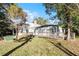 Landscaped backyard with mature trees and lawn at 203 Red Bud Ln, Longwood, FL 32779