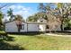 Front view of a charming white house with a walkway and well-maintained lawn at 203 Red Bud Ln, Longwood, FL 32779