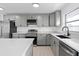 Modern kitchen with gray cabinets, stainless steel appliances, and quartz countertops at 3149 Bear Path, Kissimmee, FL 34746