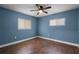 Bedroom with blue walls, wood-look floors, and ceiling fan at 36 Marigold Ln, Debary, FL 32713