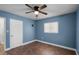 Blue walls, wood-look floors, ceiling fan, and white door at 36 Marigold Ln, Debary, FL 32713