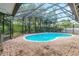 An enclosed kidney-shaped swimming pool with brick decking at 402 Satsuma Dr, Sanford, FL 32771