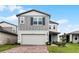 Two-story house with gray siding, brick driveway and landscaping at 4932 Mainsail St, Haines City, FL 33844