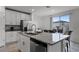 Modern kitchen with white cabinets, granite countertops, and stainless steel appliances at 4932 Mainsail St, Haines City, FL 33844
