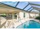 Inviting, refreshing pool with a screened enclosure and a covered patio at 5810 Penney Ln, The Villages, FL 32163