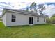 Rear view of single-story house with sliding glass doors and grassy yard at 15460 Sw 47Th Avenue Rd, Ocala, FL 34473