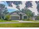 One-story house with green exterior, two-car garage, and landscaped yard at 24414 Woodhill Ct, Sorrento, FL 32776