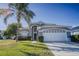 Two-story house with gray siding, white garage door, and palm tree in front at 2214 Wyndham Palms Way, Kissimmee, FL 34747