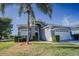 Two-story house with gray siding, white garage door, and palm tree in front at 2214 Wyndham Palms Way, Kissimmee, FL 34747