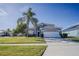 Two-story house with gray siding, white garage door, and palm tree in front at 2214 Wyndham Palms Way, Kissimmee, FL 34747