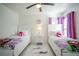 Twin bedroom with white beds, purple accents, and a ceiling fan at 8048 King Palm Cir, Kissimmee, FL 34747