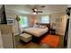 Main bedroom with king-size bed, wood flooring, and an ottoman at 245 Lake Seminary Cir, Maitland, FL 32751