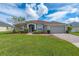 Single-story home with two-car garage, manicured lawn, and brick paver driveway at 344 Barbera Dr, Davenport, FL 33897