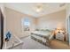 Main bedroom with king-size bed, window, ceiling fan, and light beige walls at 17846 Se 125Th Cir, Summerfield, FL 34491