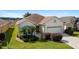 One-story house with a beige exterior, brown tile roof, and a two-car garage at 17846 Se 125Th Cir, Summerfield, FL 34491