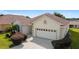 One-story home with light beige exterior, brown roof, and a two-car garage at 17846 Se 125Th Cir, Summerfield, FL 34491