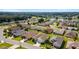 Aerial view of a community featuring numerous houses, palm trees, and a lake in the distance at 17846 Se 125Th Cir, Summerfield, FL 34491