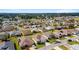 Aerial view of a residential neighborhood with houses, palm trees and a lake at 17846 Se 125Th Cir, Summerfield, FL 34491