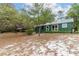 Green house exterior with a screened porch and large trees at 22649, 22645 And Tbd Ne 105Th Avenue Rd, Fort Mc Coy, FL 32134