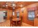 Wood paneled dining area with round table and view into kitchen at 22649, 22645 And Tbd Ne 105Th Avenue Rd, Fort Mc Coy, FL 32134
