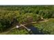 Aerial view showcasing a lakefront property with lush trees and a dock at 22649, 22645 And Tbd Ne 105Th Avenue Rd, Fort Mc Coy, FL 32134