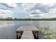 Serene lake view with a wooden dock, lush greenery, and cloudy sky at 22649, 22645 And Tbd Ne 105Th Avenue Rd, Fort Mc Coy, FL 32134