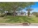 Mobile home with a lush lawn and palm trees in the front at 1618 Cypress Pt, Lady Lake, FL 32159