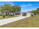 Mobile home exterior with a large driveway and well-maintained lawn at 1618 Cypress Pt, Lady Lake, FL 32159