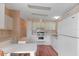 White kitchen cabinets, stove, refrigerator, and wood flooring at 1618 Cypress Pt, Lady Lake, FL 32159