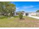 White single-story home with a landscaped lawn and driveway at 1618 Cypress Pt, Lady Lake, FL 32159