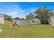 View of the home's rear, showcasing a detached garage and landscaping at 1618 Cypress Pt, Lady Lake, FL 32159